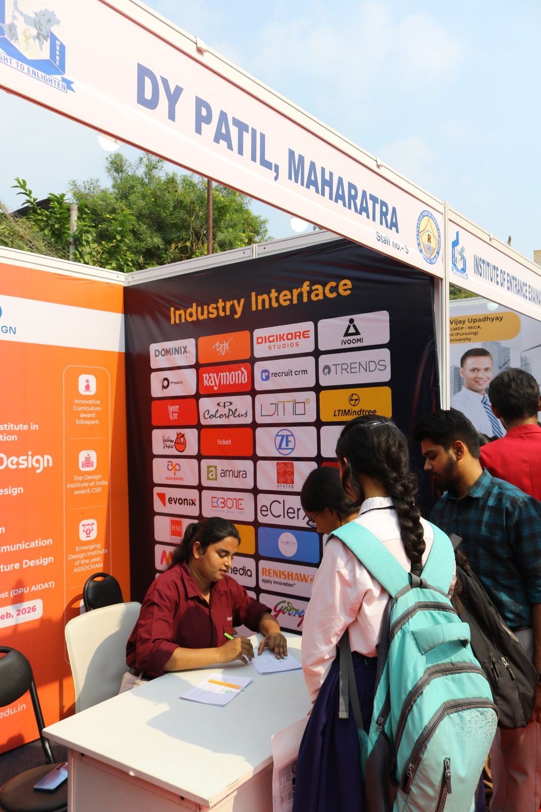 Student speaking with a representative at a university stall at a career fair