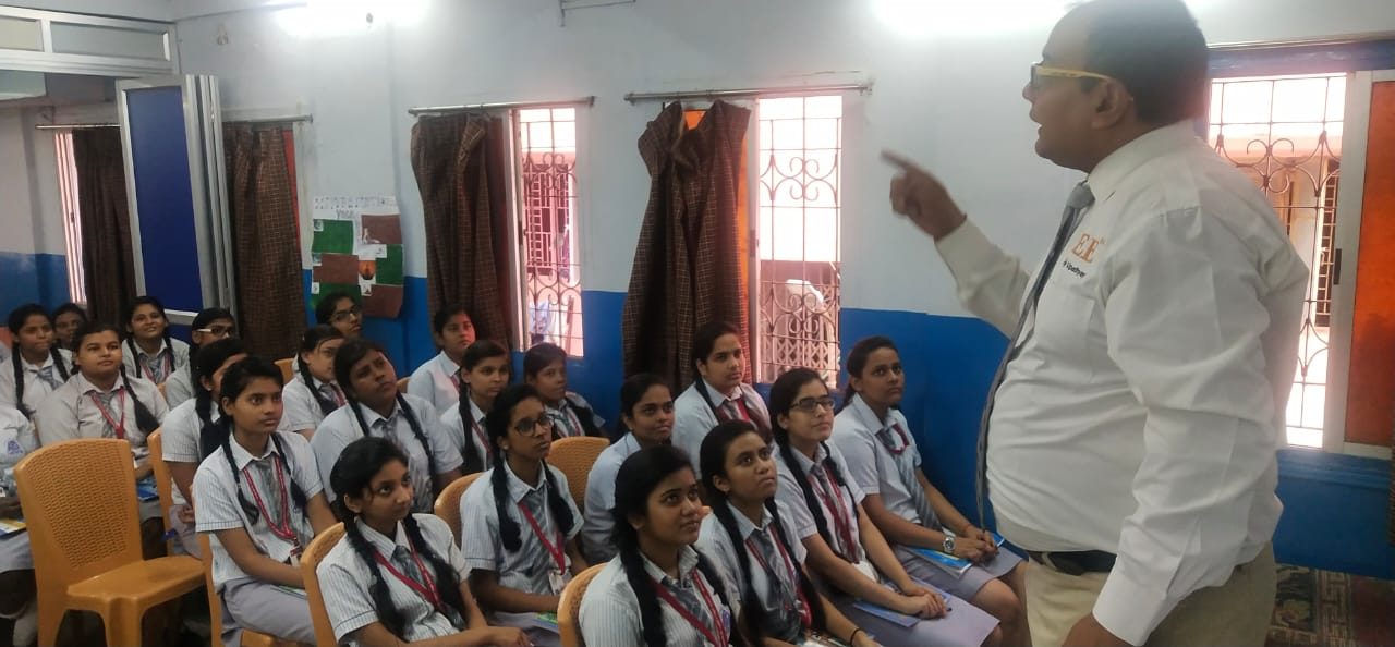 Speaker addressing girl students seated in a classroom