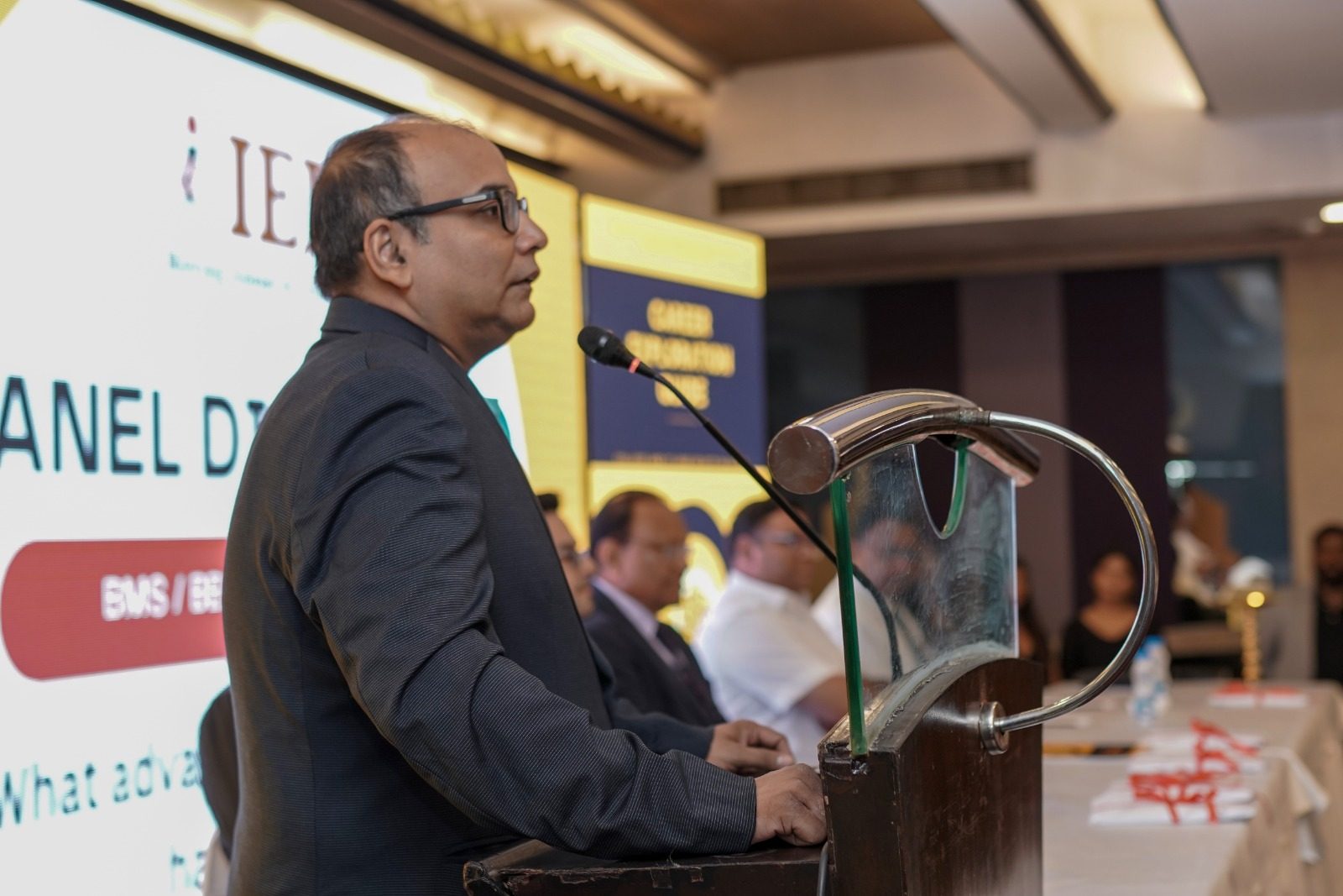 Speaker at a podium at a career event with panelists seated behind
