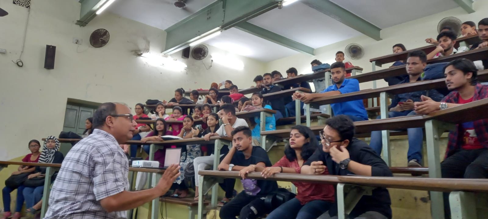 Speaker talking with college students in a tiered lecture hall